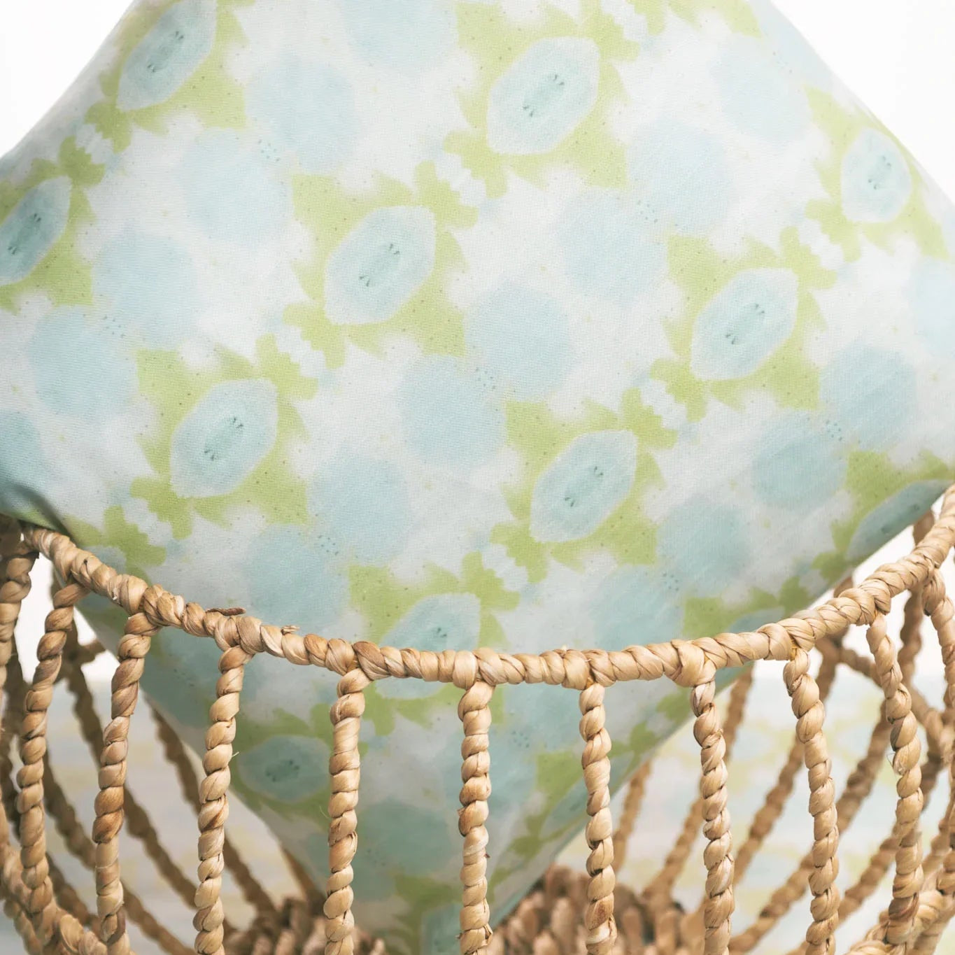 Luxury decorative pillow featuring an abstract small repeat pattern in chartreuse green and soft blue tones, styled for a layered modern traditional interior.
